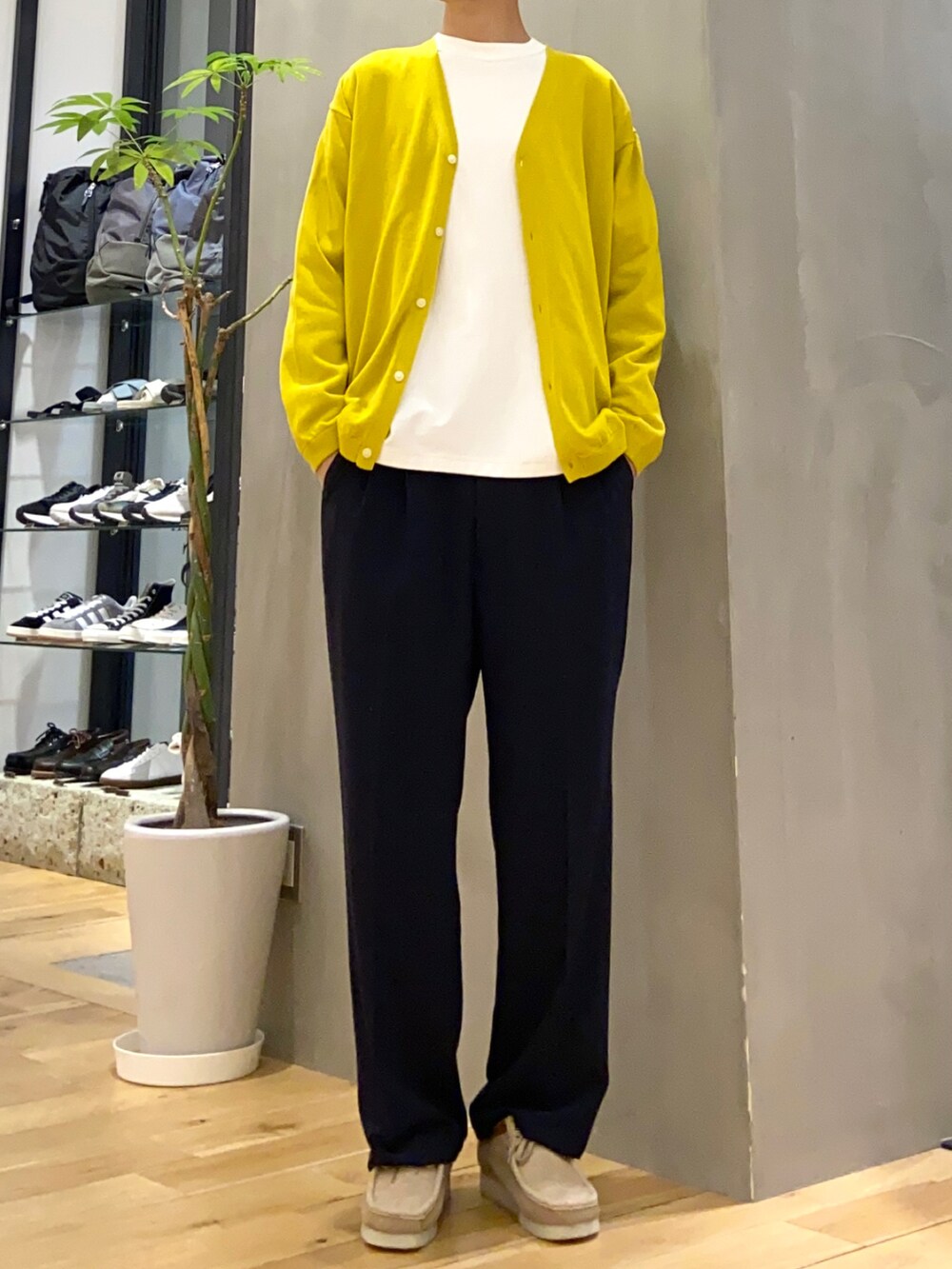 イエロー系のカーディガン/ボレロ、ホワイト系のTシャツ/カットソー、ブルー系のスラックスを着用したメンズの春コーディネートの3枚目の写真