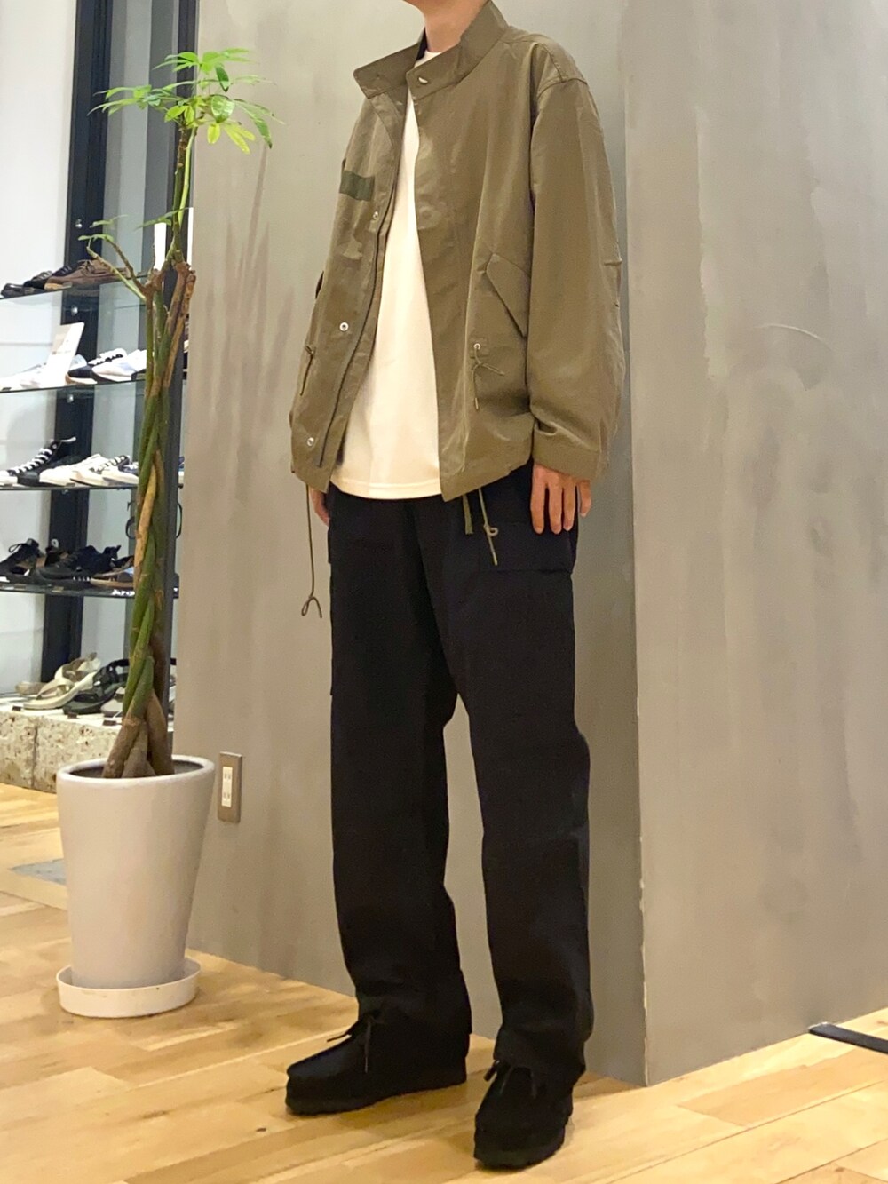 グリーン系のモッズコート、ホワイト系のTシャツ/カットソー、ブラック系のその他パンツを着用したメンズの秋コーディネートの3枚目の写真