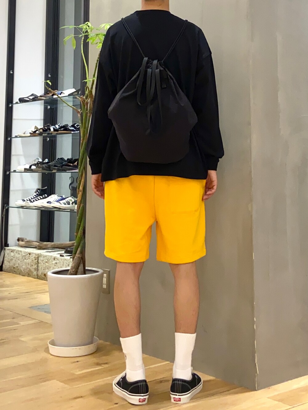 ブラック系のTシャツ/カットソー、ブラック系のバックパック/リュック、イエロー系のその他パンツを着用したメンズの夏コーディネートの4枚目の写真