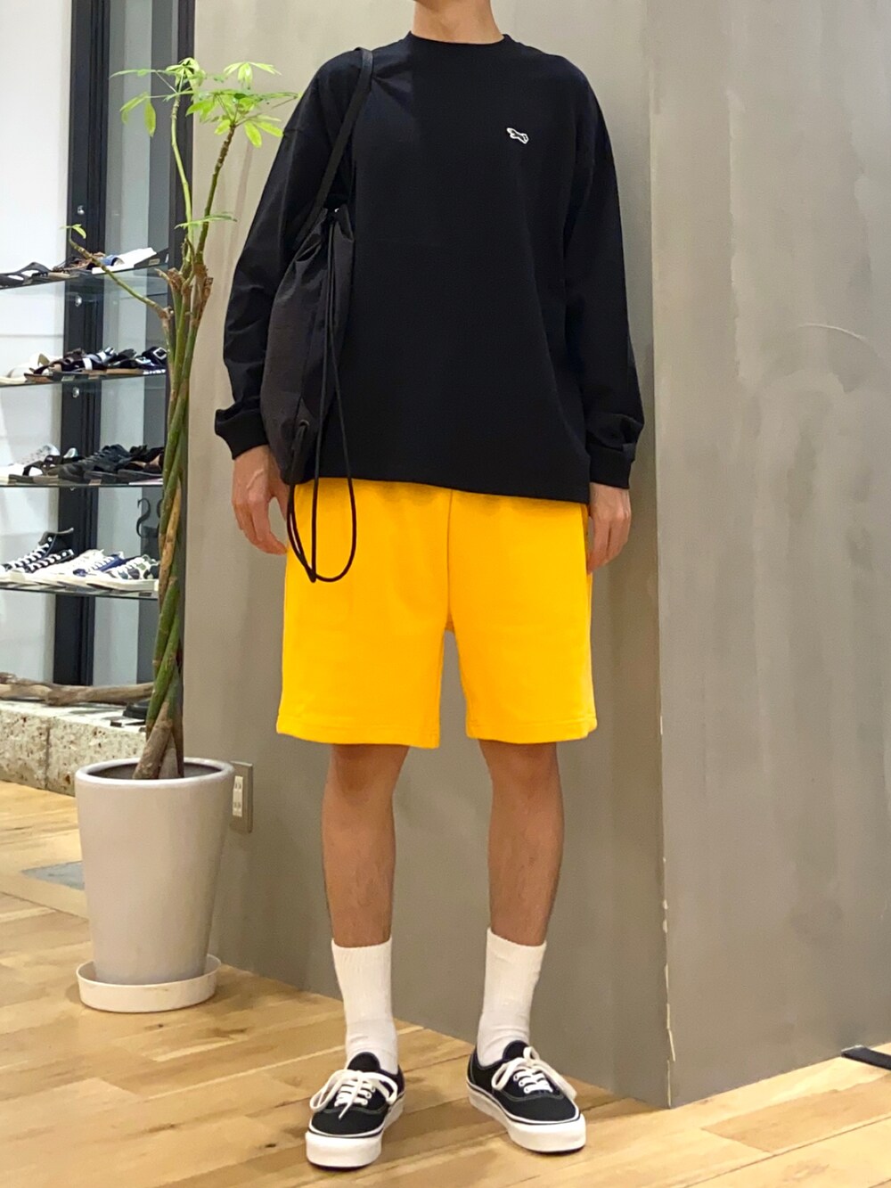 ブラック系のTシャツ/カットソー、ブラック系のバックパック/リュック、イエロー系のその他パンツを着用したメンズの夏コーディネートの5枚目の写真