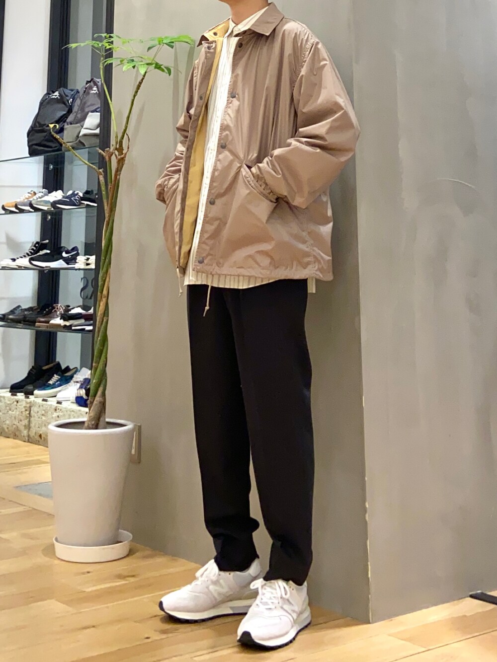 ホワイト系のシャツ/ブラウス、ブラック系のスラックス、ホワイト系のスニーカーを着用したメンズの春コーディネートの3枚目の写真