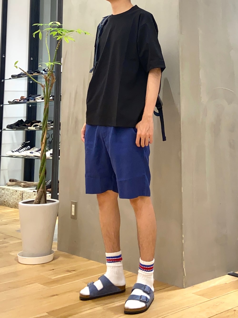 ブラック系のTシャツ/カットソー、ブルー系のその他パンツ、ブルー系のバックパック/リュックを着用したメンズの夏コーディネートの3枚目の写真