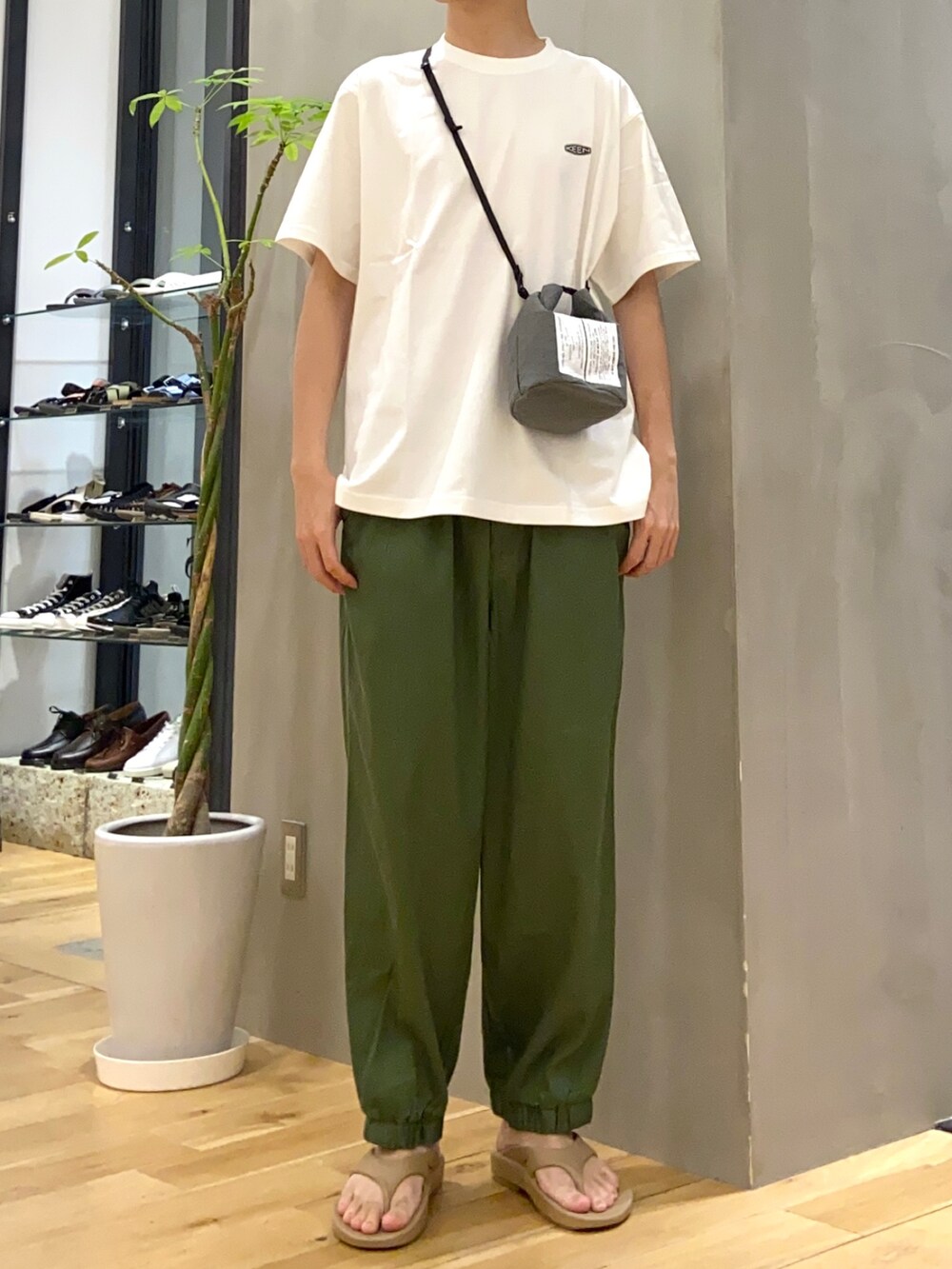 ホワイト系のTシャツ/カットソー、グリーン系のショルダーバッグ、グリーン系のその他パンツを着用したメンズの夏コーディネートの3枚目の写真