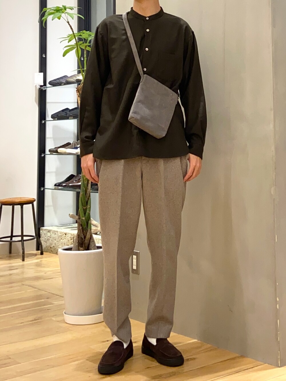 ブラウン系のシャツ/ブラウス、グレー系のショルダーバッグ、ブラウン系のローファーを着用したメンズの冬コーディネートの3枚目の写真