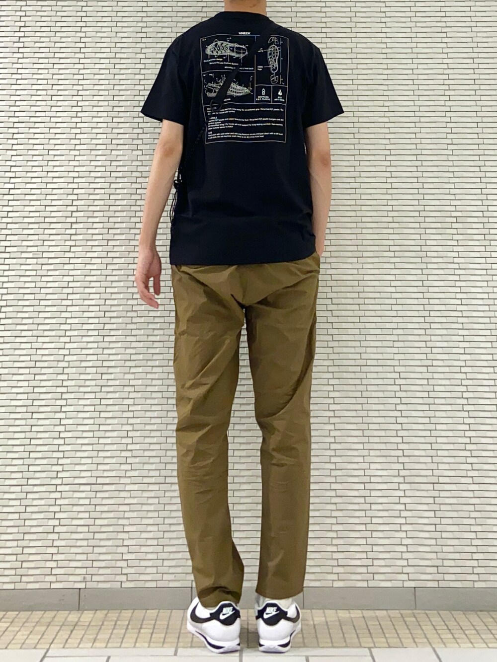 ブラック系のTシャツ/カットソー、ベージュ系のショルダーバッグ、ブラック系のその他パンツを着用したメンズの春コーディネートの3枚目の写真
