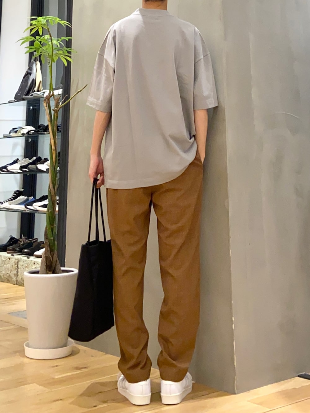 グレー系のTシャツ/カットソー、ブラウン系のその他パンツ、ブラック系のトートバッグを着用したメンズの春コーディネートの3枚目の写真