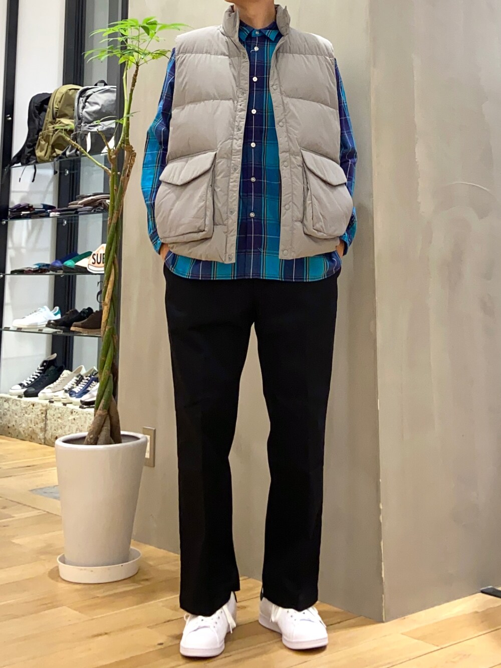 グレー系のダウンベスト、ブラック系のその他パンツ、ブラック系のスニーカーを着用したメンズの秋コーディネートの2枚目の写真