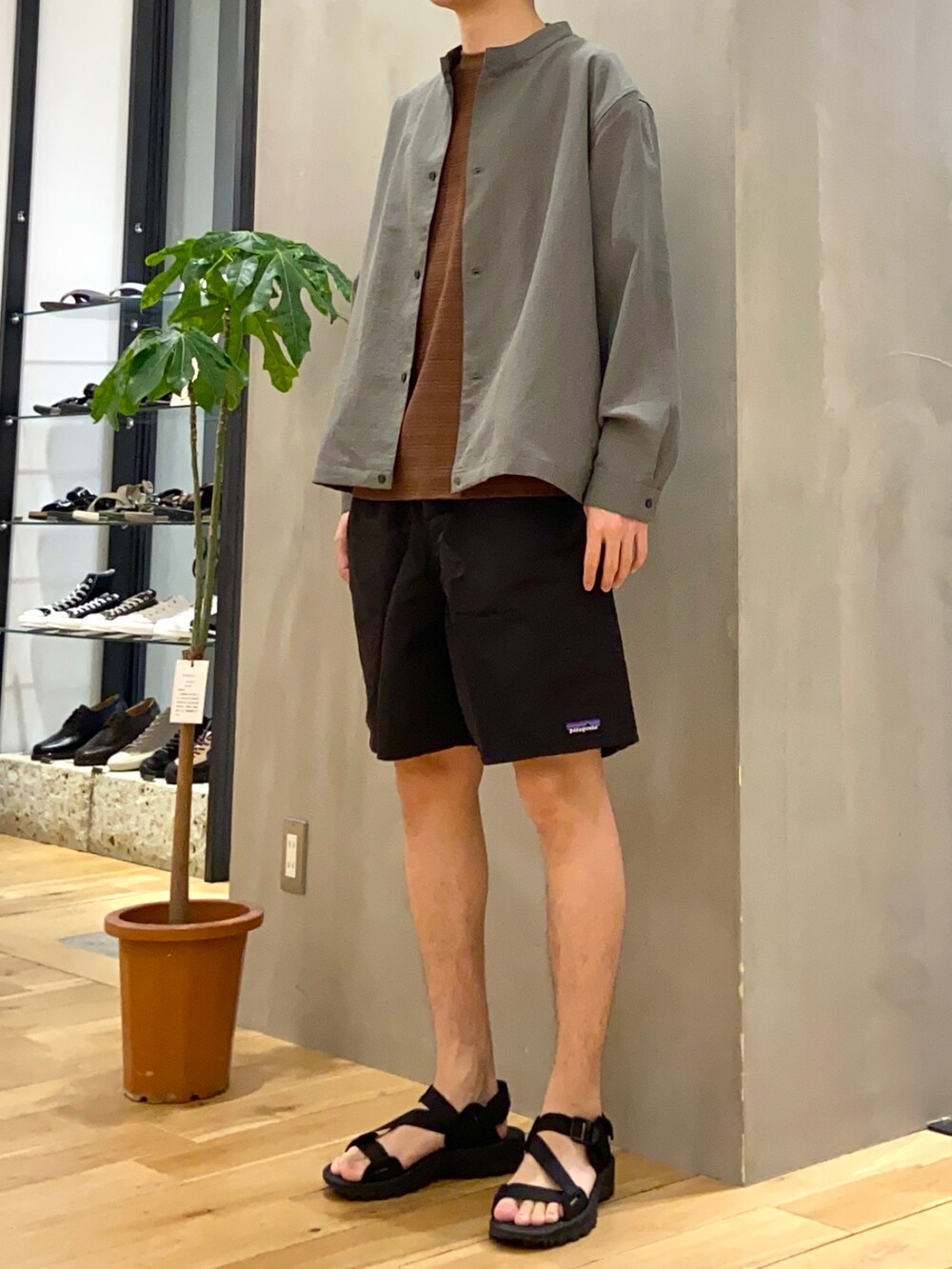 グリーン系のブルゾン、オレンジ系のTシャツ/カットソー、ブラック系のサンダルを着用したメンズの夏コーディネートの2枚目の写真