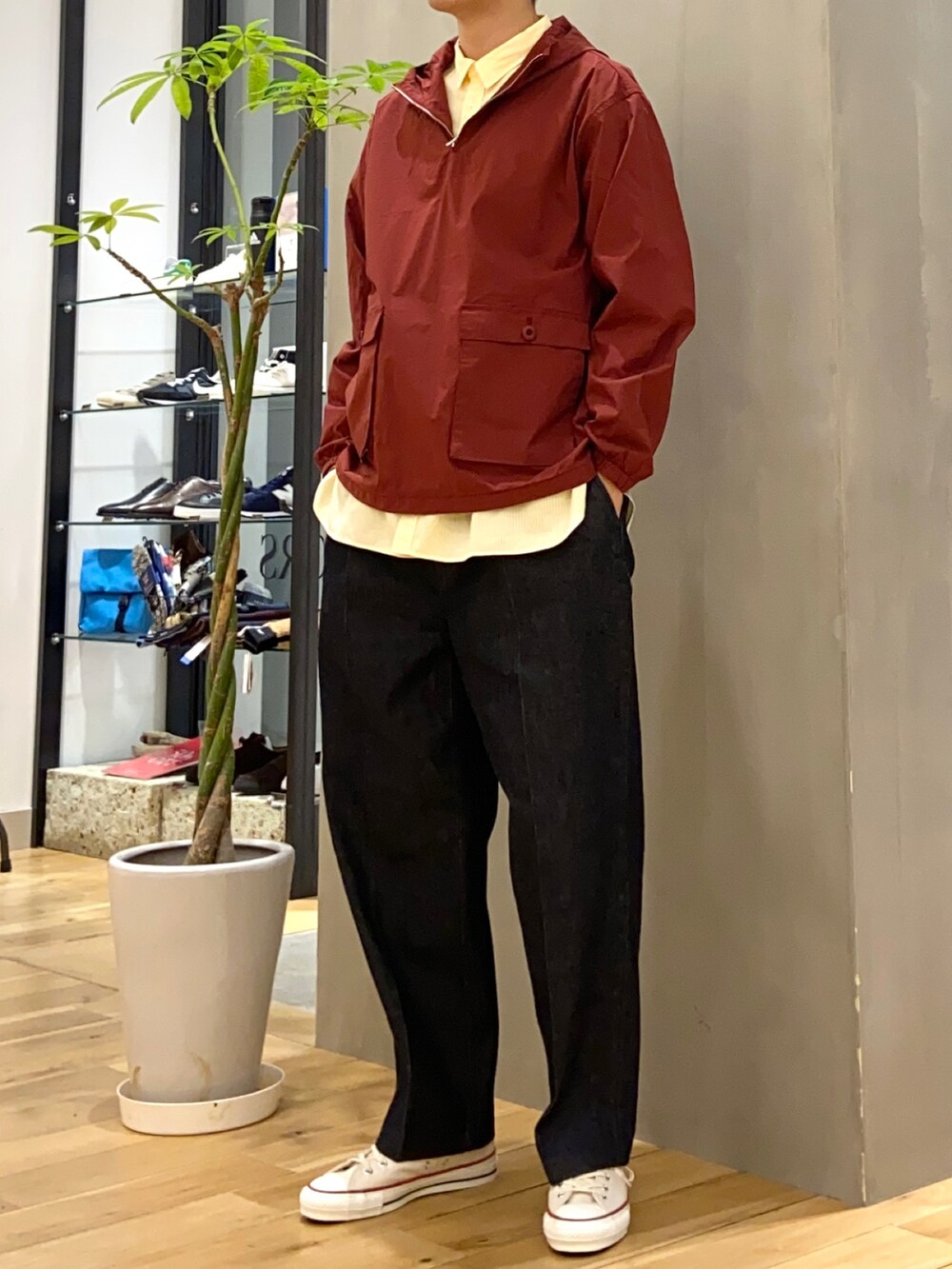 レッド系のマウンテンパーカー、イエロー系のシャツ/ブラウス、ブルー系のデニムパンツを着用したメンズの冬コーディネートの2枚目の写真