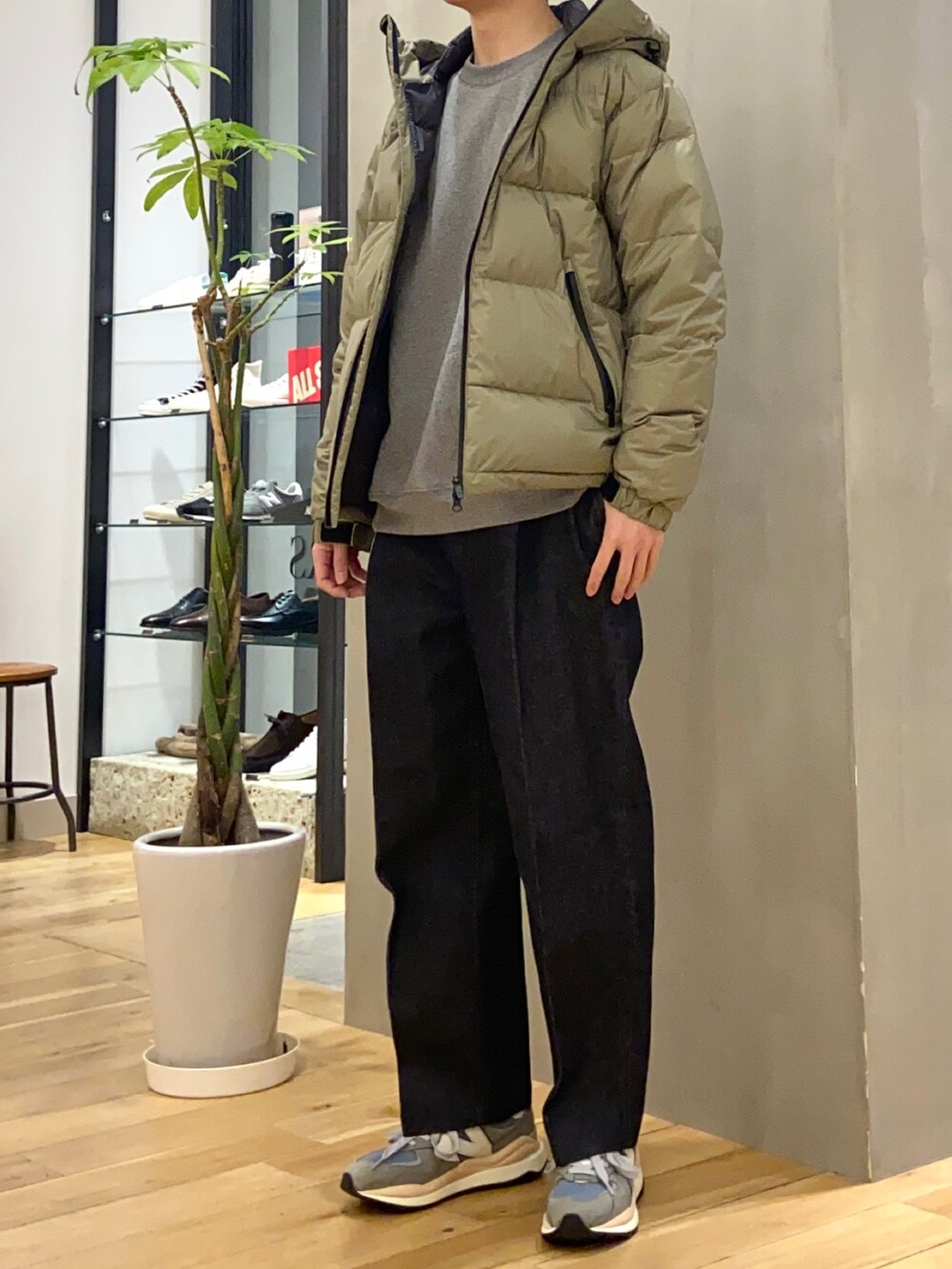 グリーン系のダウンジャケット/コート、ブルー系のデニムパンツ、グレー系のスニーカーを着用したメンズの冬コーディネートの4枚目の写真