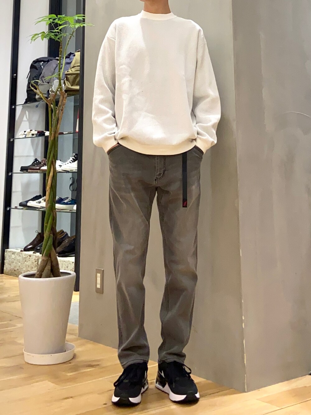 グリーン系のダウンジャケット/コート、ホワイト系のニット/セーター、ブラック系のその他パンツを着用したメンズの冬コーディネートの2枚目の写真