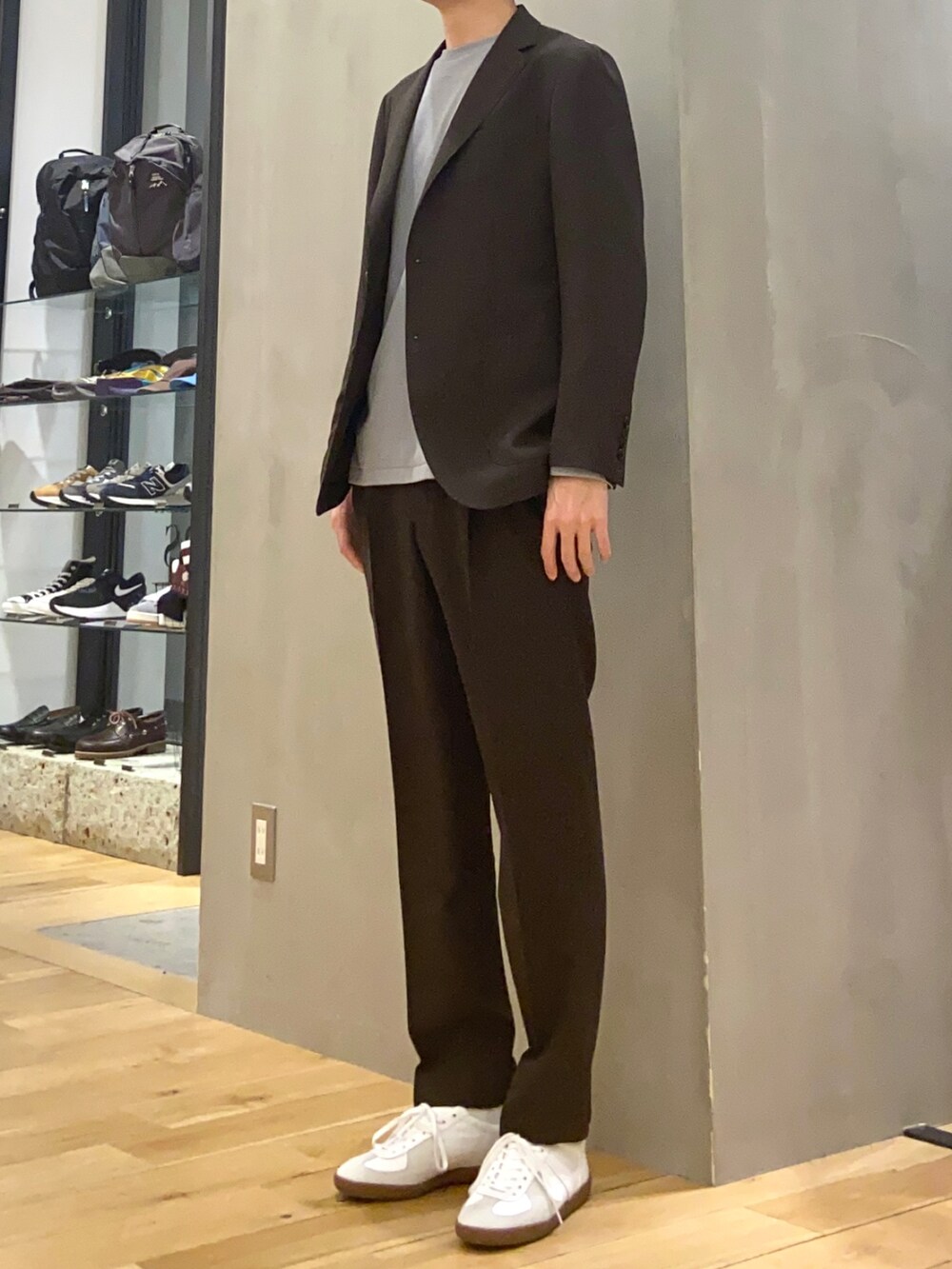 ブラウン系のスーツジャケット、ブルー系のTシャツ/カットソー、ブラウン系のスーツパンツを着用したメンズの春コーディネートの2枚目の写真