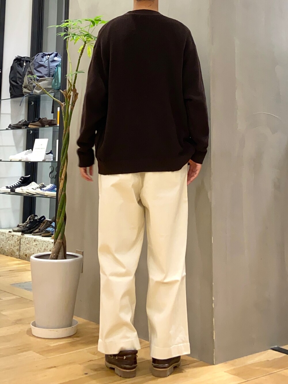 ブラウン系のカーディガン/ボレロ、ブラウン系のTシャツ/カットソー、ホワイト系のチノパンツを着用したメンズの秋コーディネートの3枚目の写真