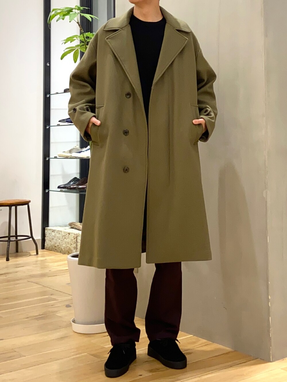 ブラック系のニット/セーター、グリーン系のチェスターコート、ブラック系のその他シューズを着用したメンズの冬コーディネートの3枚目の写真