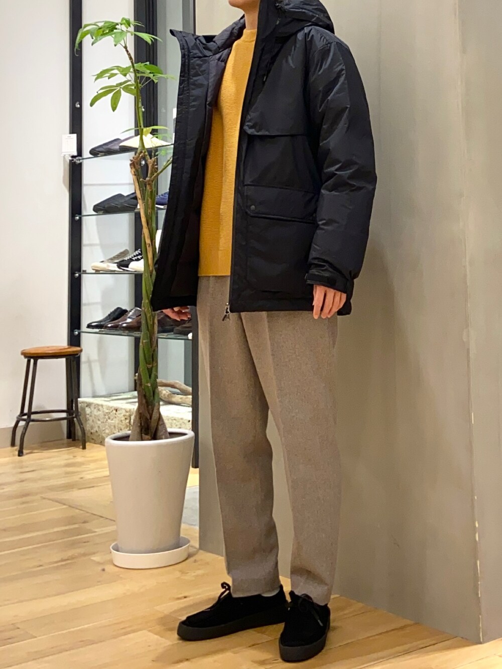 ブラック系のダウンジャケット/コート、イエロー系のニット/セーター、ブラック系のその他シューズを着用したメンズの冬コーディネートの5枚目の写真