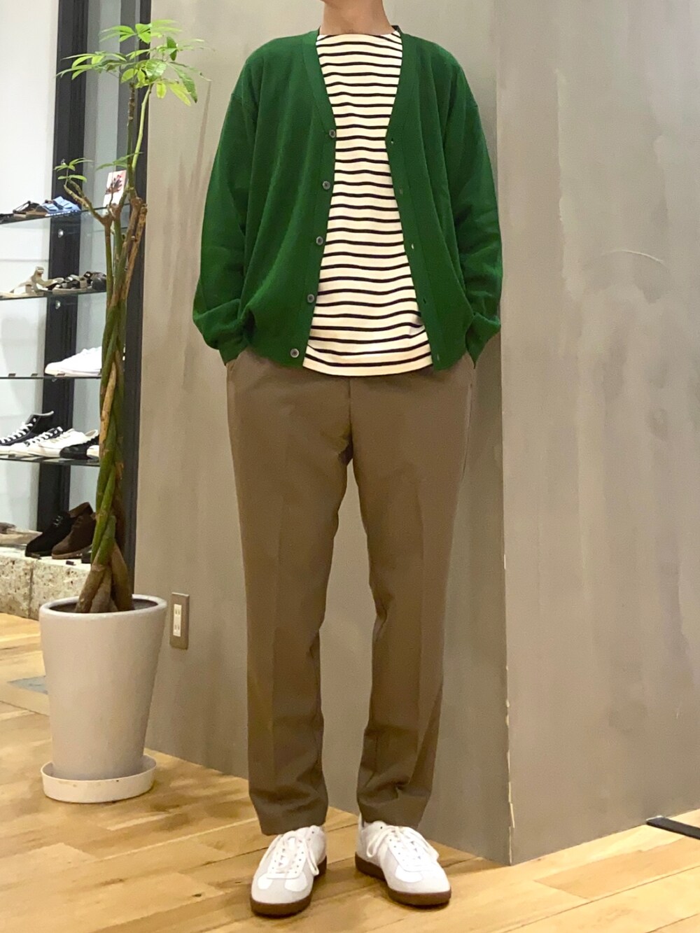 グリーン系のカーディガン/ボレロ、ホワイト系のTシャツ/カットソー、ホワイト系のスニーカーを着用したメンズの秋コーディネートの2枚目の写真