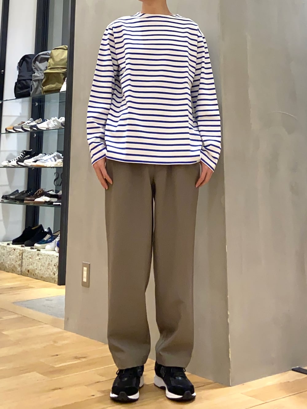 ブルー系のステンカラーコート、ブルー系のTシャツ/カットソー、ブラウン系のその他パンツを着用したメンズの春コーディネートの2枚目の写真