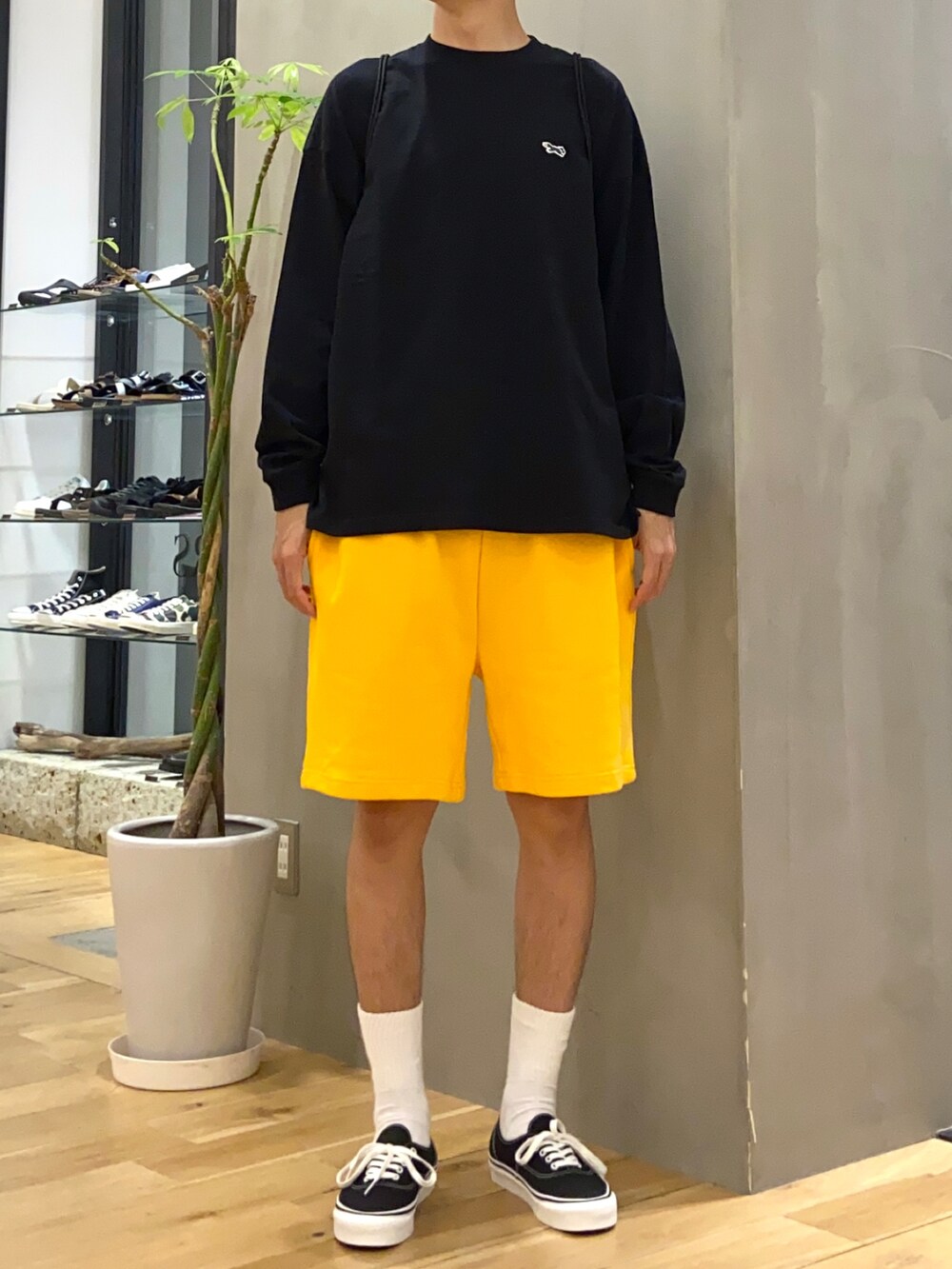 ブラック系のTシャツ/カットソー、ブラック系のバックパック/リュック、イエロー系のその他パンツを着用したメンズの夏コーディネートの2枚目の写真