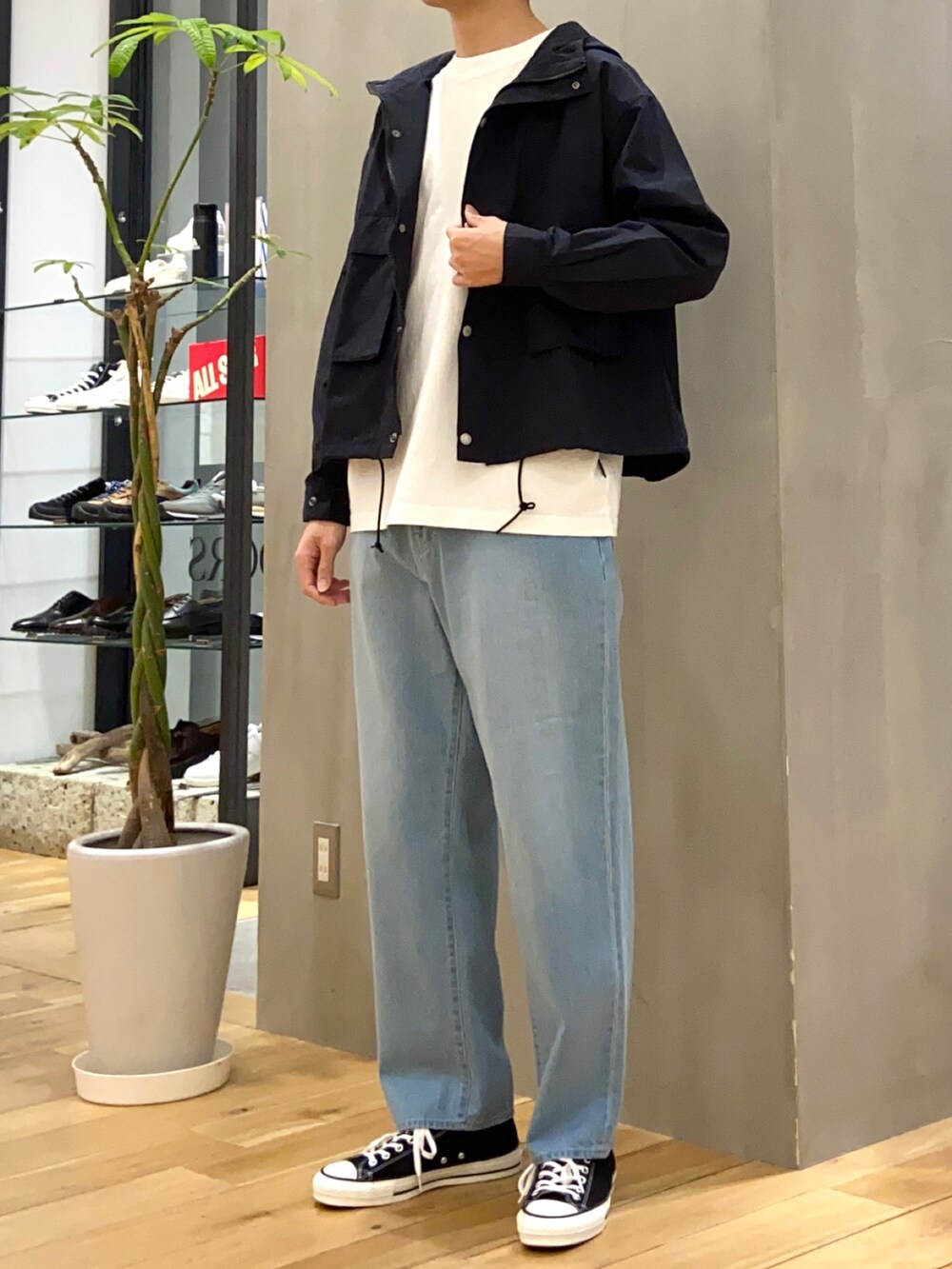 ブラック系のマウンテンパーカー、ホワイト系のTシャツ/カットソー、ブルー系のデニムパンツを着用したメンズの春コーディネートの5枚目の写真