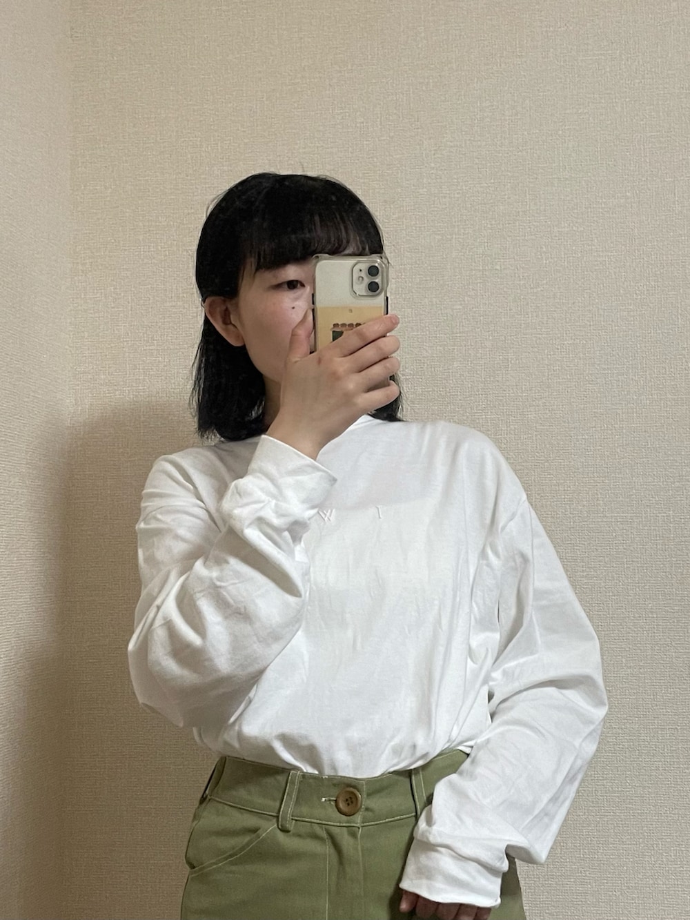 グリーン系のパンツ、グリーン系のショルダーバッグ、ホワイト系のTシャツ/カットソーを着用したレディースの春コーディネートの2枚目の写真