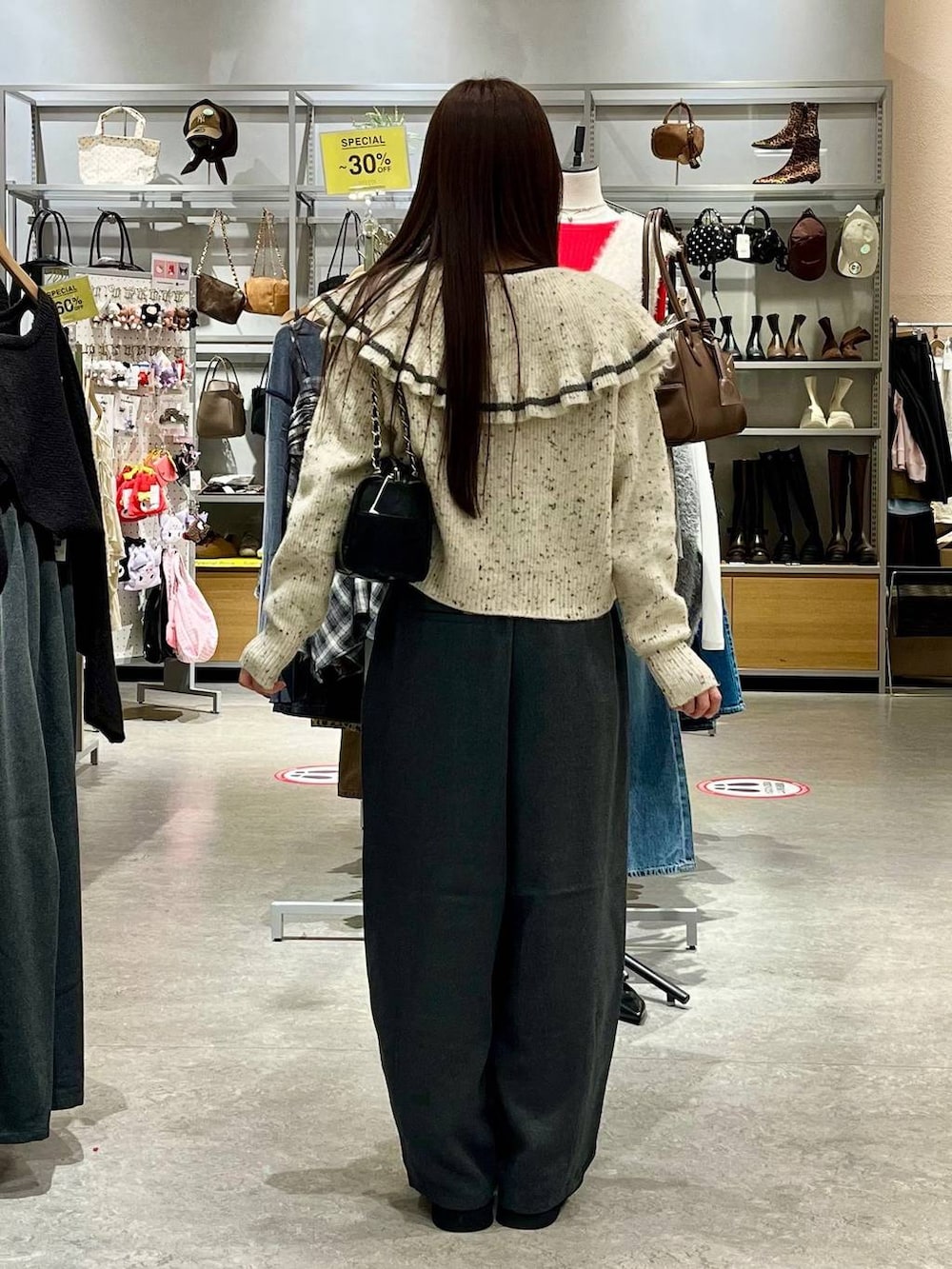 ブラック系のサンダル、ベージュ系のニット/セーター、ブラック系のショルダーバッグを着用したレディースの秋コーディネートの4枚目の写真