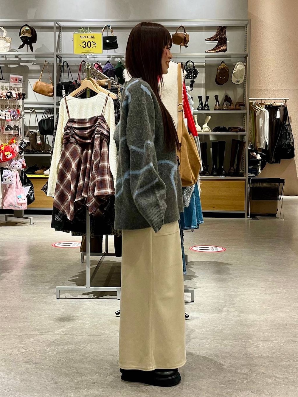 ホワイト系のスカート、ブラック系のサンダル、ブラック系のボストンバッグを着用したレディースの秋コーディネートの5枚目の写真