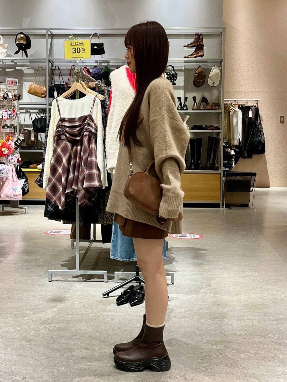 ブラウン系のブーツ、ブラウン系のスカート、ブラウン系のボストンバッグを着用したレディースの秋コーディネートの3枚目の写真