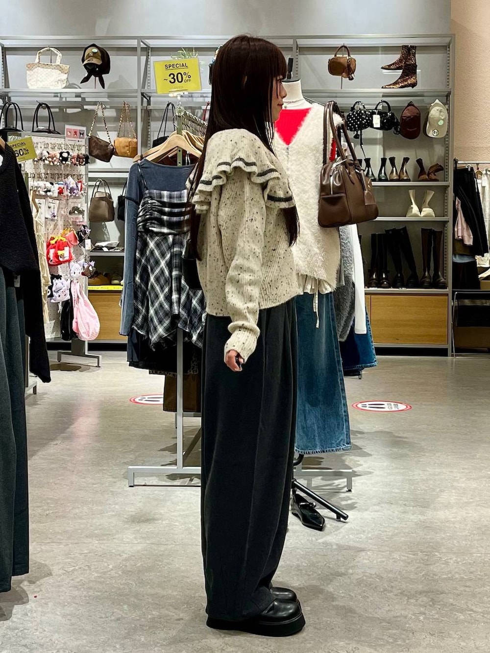 ブラック系のサンダル、ベージュ系のニット/セーター、ブラック系のショルダーバッグを着用したレディースの秋コーディネートの5枚目の写真