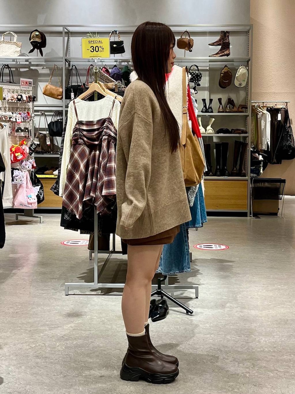 ブラウン系のブーツ、ブラウン系のスカート、ブラウン系のボストンバッグを着用したレディースの秋コーディネートの5枚目の写真