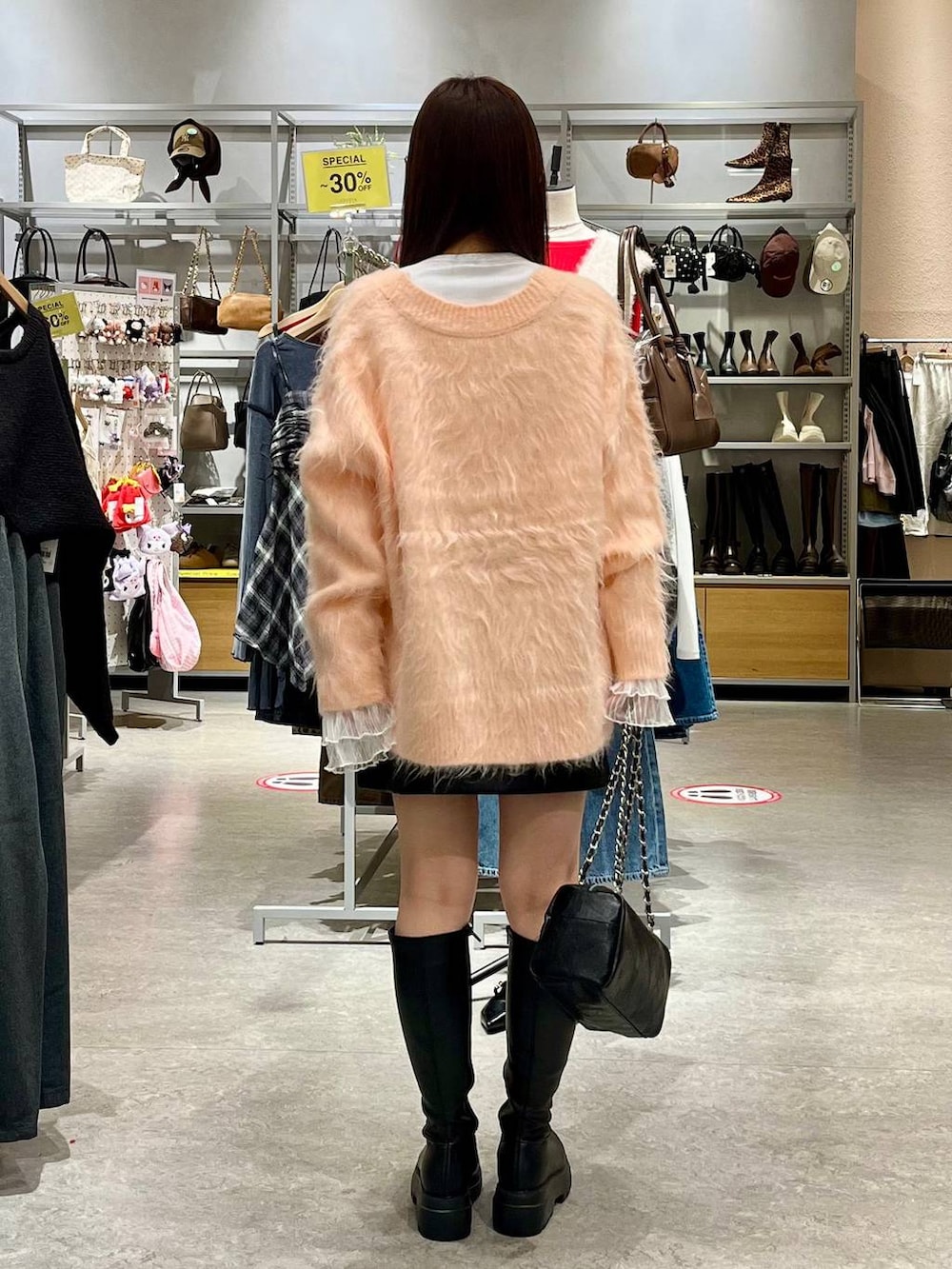 ブラック系のスカート、ホワイト系のTシャツ/カットソー、ブラック系のブーツを着用したレディースの秋コーディネートの4枚目の写真