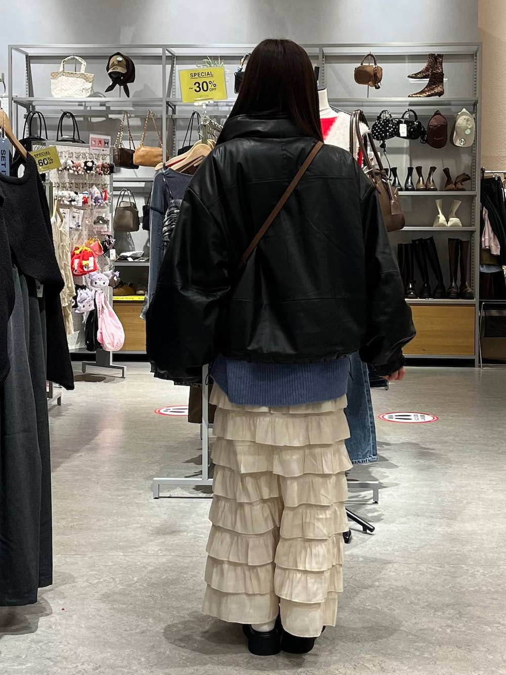 ホワイト系のスカート、ブラック系のサンダル、ブラック系のブルゾンを着用したレディースの秋コーディネートの4枚目の写真