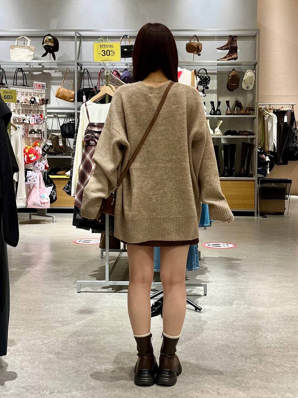 ブラウン系のブーツ、ブラウン系のスカート、ブラウン系のボストンバッグを着用したレディースの秋コーディネートの4枚目の写真