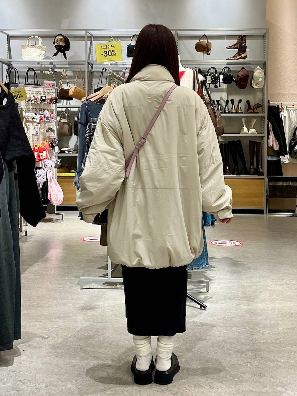 ホワイト系のブルゾン、ブラック系のサンダル、ピンク系のボストンバッグを着用したレディースの秋コーディネートの4枚目の写真