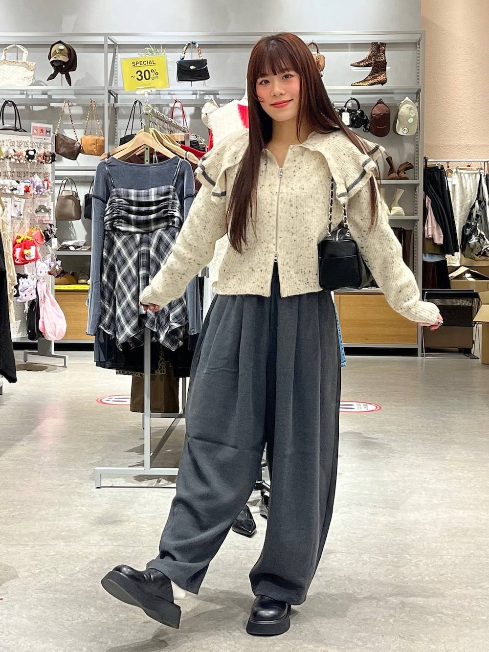 ブラック系のサンダル、ベージュ系のニット/セーター、ブラック系のショルダーバッグを着用したレディースの秋コーディネートの2枚目の写真