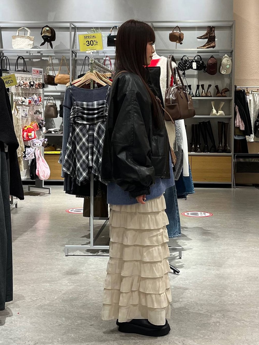 ホワイト系のスカート、ブラック系のサンダル、ブラック系のブルゾンを着用したレディースの秋コーディネートの5枚目の写真