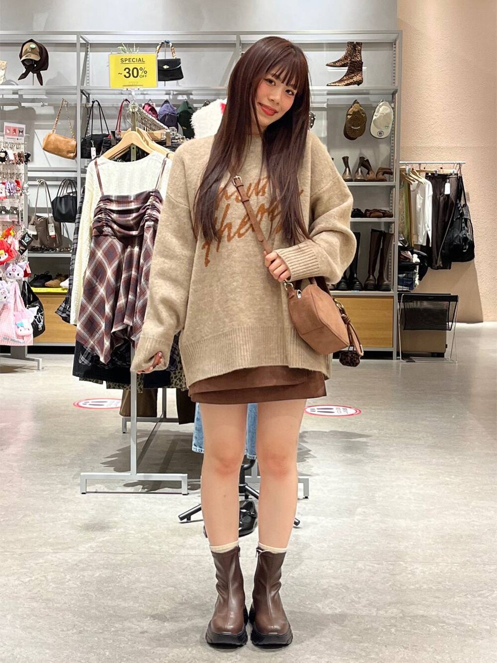 ブラウン系のブーツ、ブラウン系のスカート、ブラウン系のボストンバッグを着用したレディースの秋コーディネートの2枚目の写真