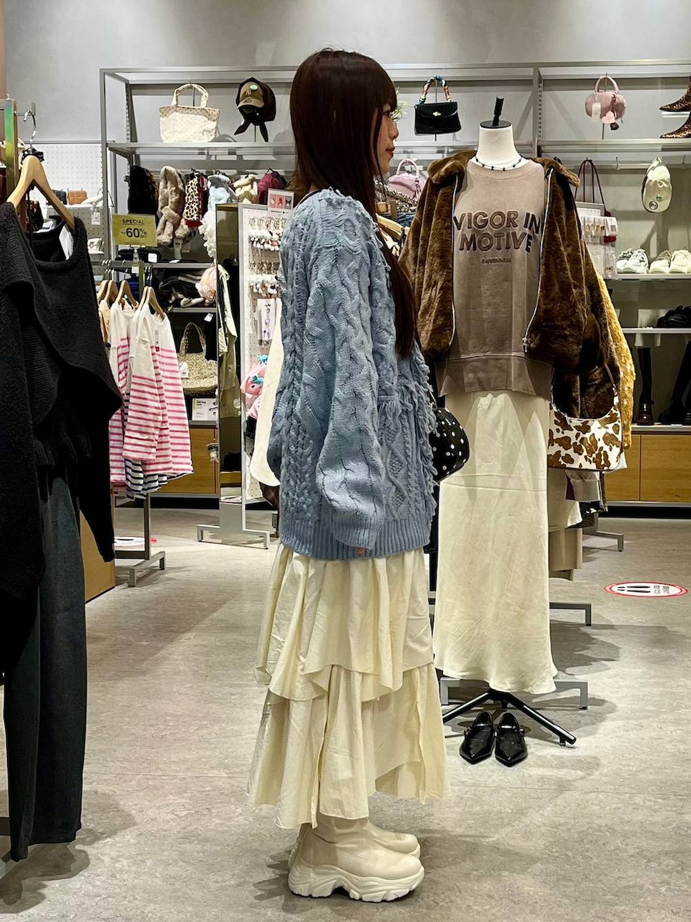 ホワイト系のブーツ、ホワイト系のスカート、その他のボストンバッグを着用したレディースの秋コーディネートの5枚目の写真