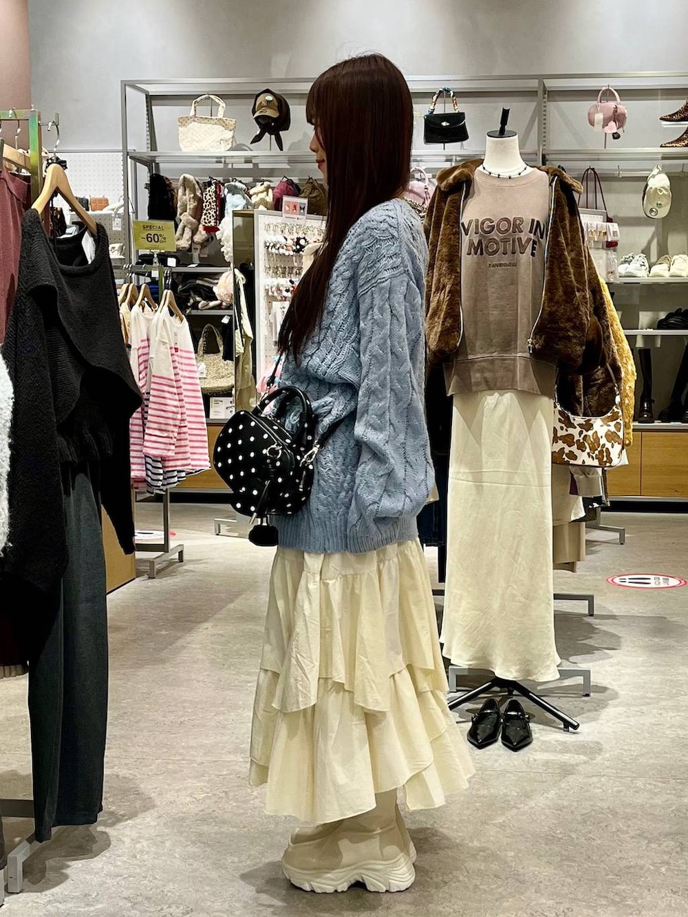 ホワイト系のブーツ、ホワイト系のスカート、その他のボストンバッグを着用したレディースの秋コーディネートの3枚目の写真