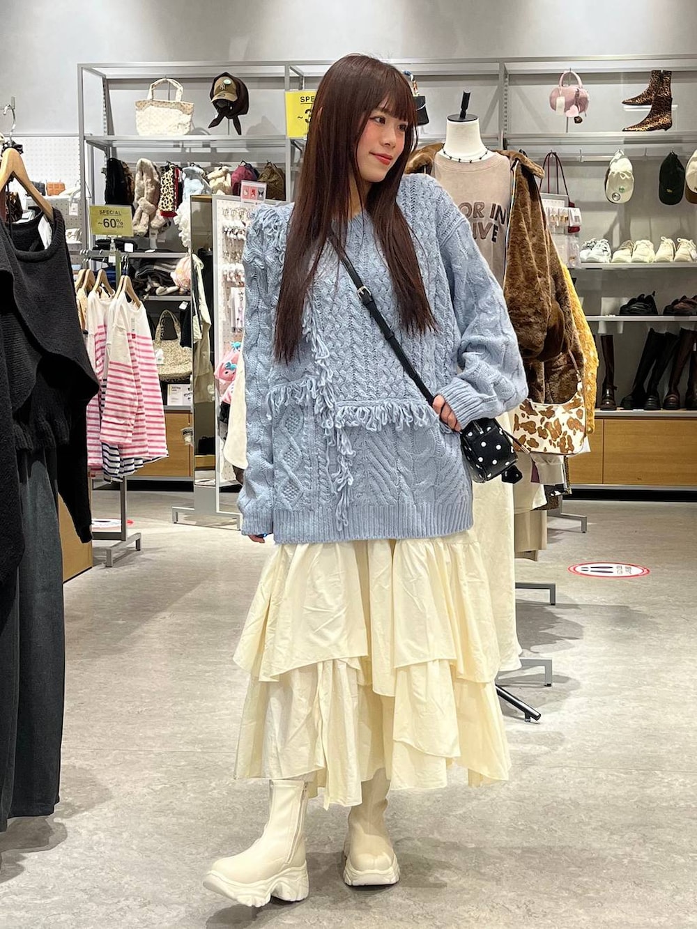 ホワイト系のブーツ、ホワイト系のスカート、その他のボストンバッグを着用したレディースの秋コーディネートの2枚目の写真