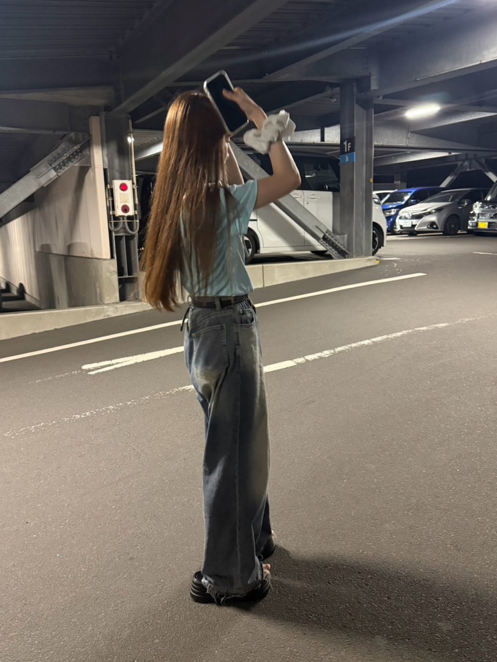 ブルー系のデニムパンツ、ブルー系のTシャツ/カットソー、ブラック系のサンダルを着用したレディースの秋コーディネートの3枚目の写真