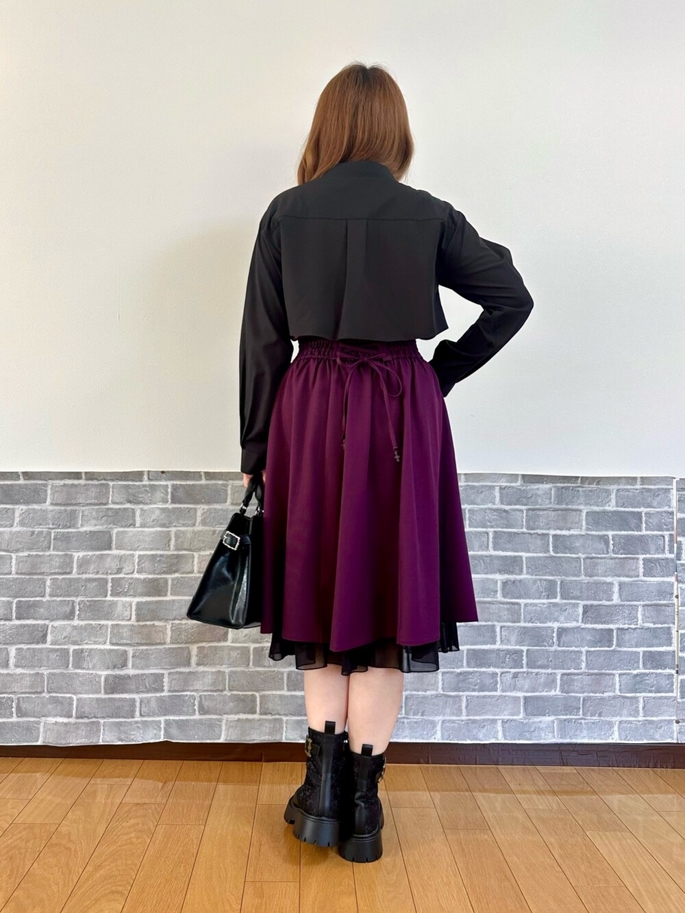 ブラック系のシャツ/ブラウス、ブラック系のカーディガン/ボレロ、パープル系のスカートを着用したレディースの秋コーディネートの4枚目の写真