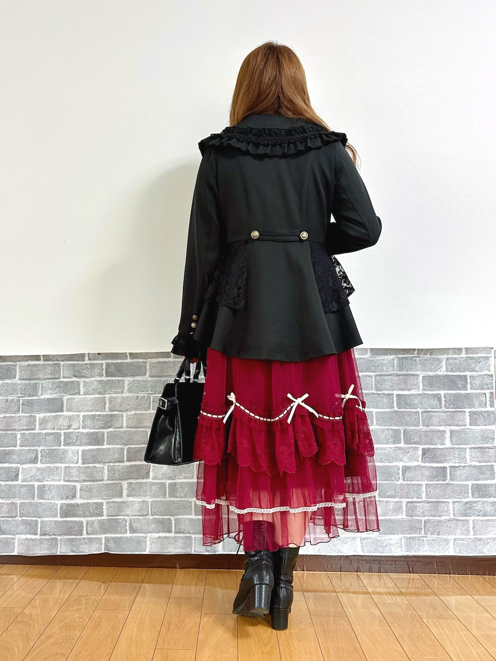 ブラック系のテーラードジャケット、ブラック系のニット/セーター、ホワイト系のタンクトップを着用したレディースの秋コーディネートの4枚目の写真