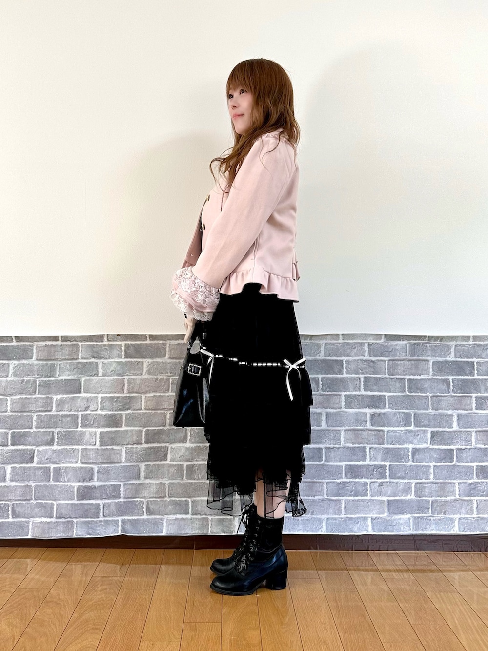 ピンク系のピーコート、ブラック系のスカート、ブラック系のボストンバッグを着用したレディースの秋コーディネートの4枚目の写真