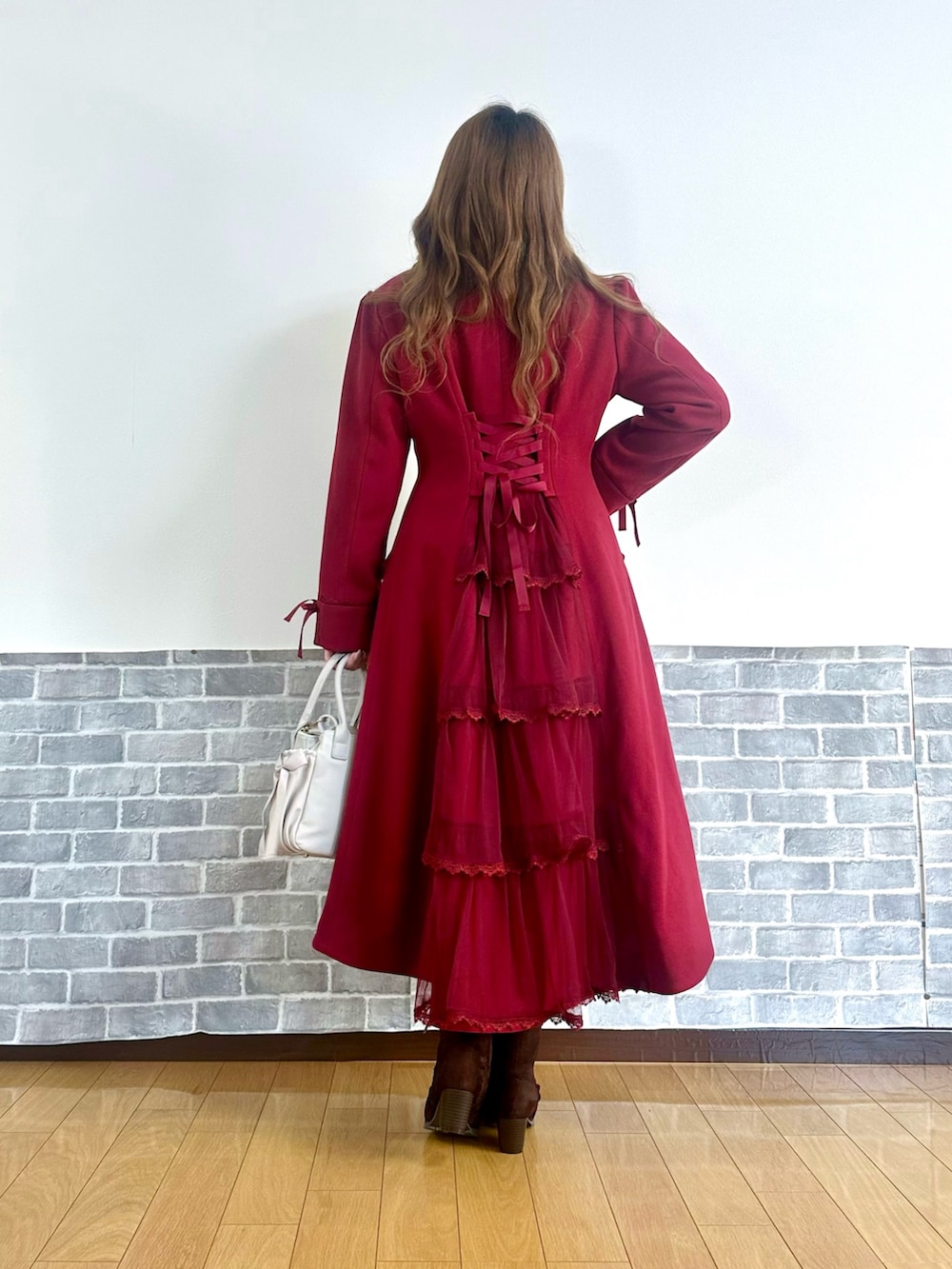 レッド系のダッフルコート、ホワイト系のTシャツ/カットソー、ホワイト系のニット/セーターを着用したレディースの冬コーディネートの4枚目の写真