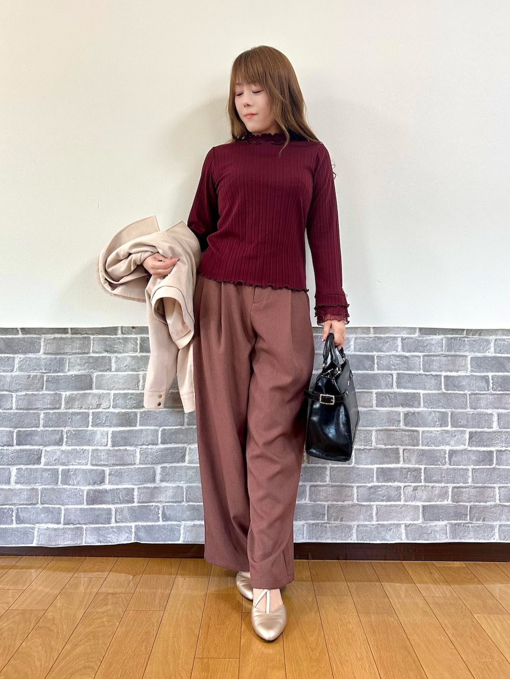 パープル系のダッフルコート、レッド系のTシャツ/カットソー、ベージュ系のパンプスを着用したレディースの冬コーディネートの2枚目の写真