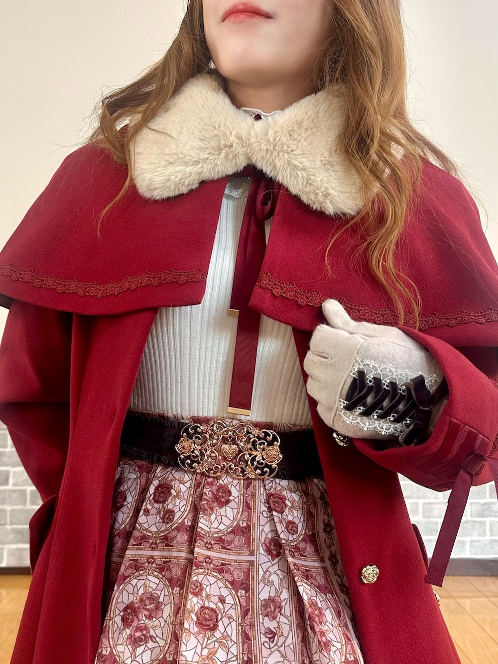 レッド系のダッフルコート、ホワイト系のTシャツ/カットソー、ホワイト系のニット/セーターを着用したレディースの冬コーディネートの6枚目の写真