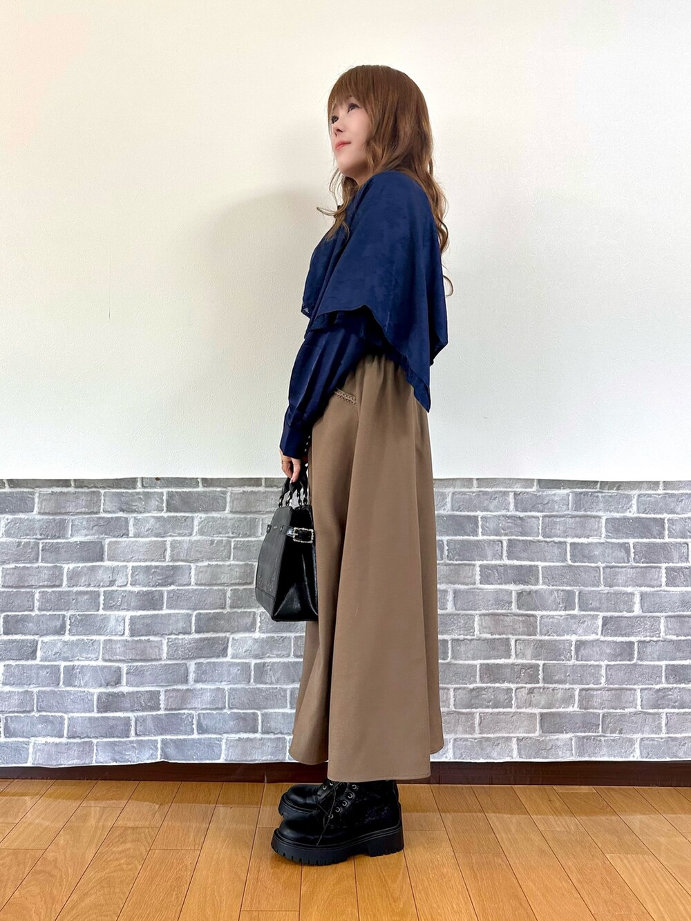 ブラック系のタンクトップ、ブルー系のシャツ/ブラウス、ブラウン系のスカートを着用したレディースの秋コーディネートの3枚目の写真