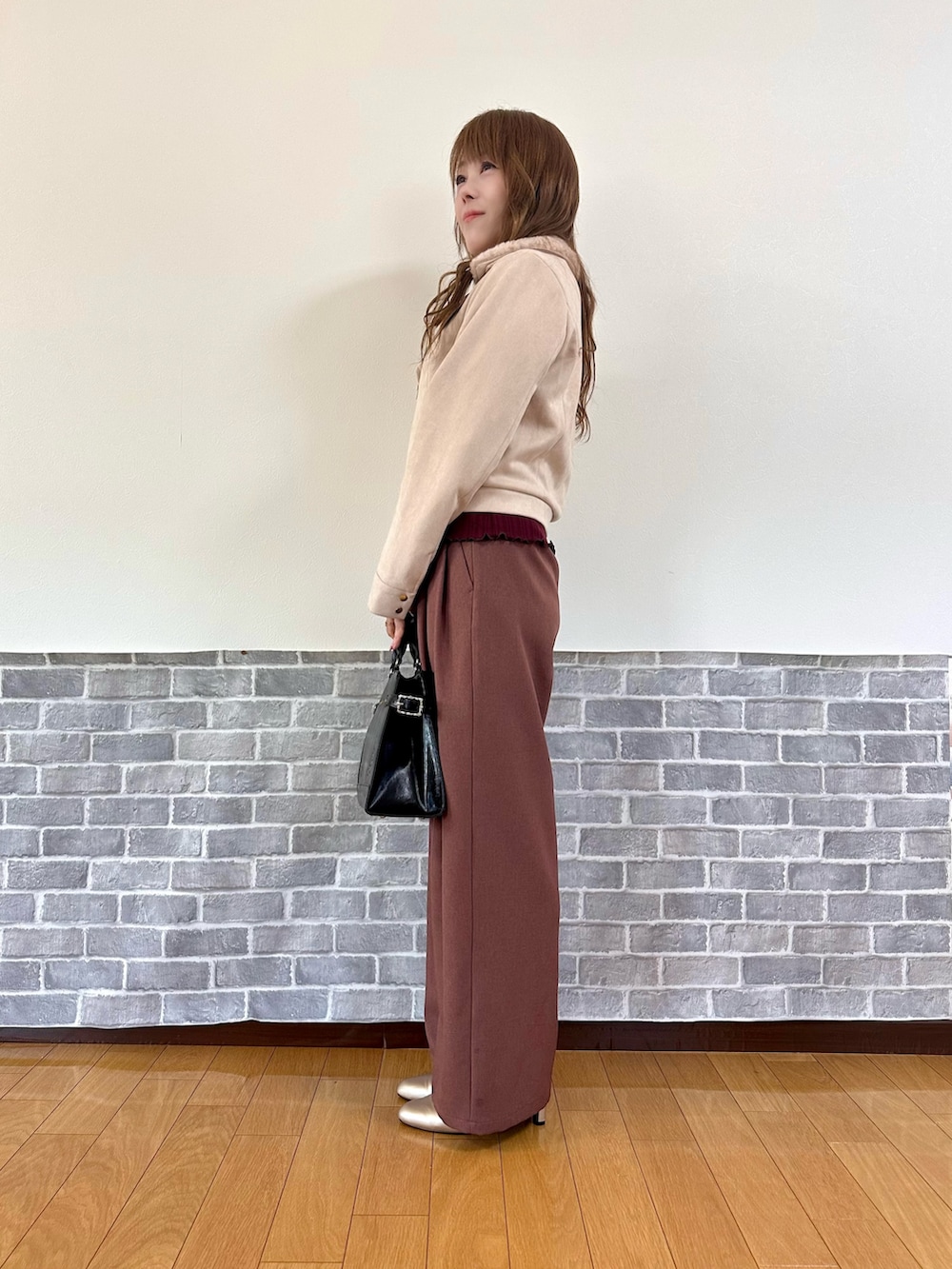 パープル系のダッフルコート、レッド系のTシャツ/カットソー、ベージュ系のパンプスを着用したレディースの冬コーディネートの4枚目の写真