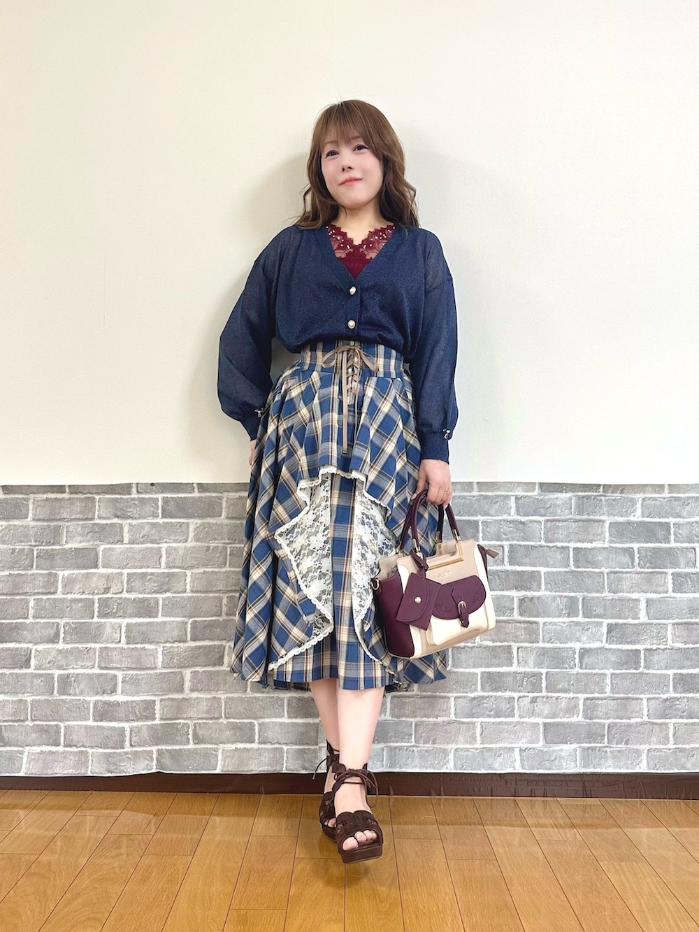 レッド系のタンクトップ、ブルー系のカーディガン/ボレロ、ブルー系のスカートを着用したレディースの夏コーディネートの2枚目の写真