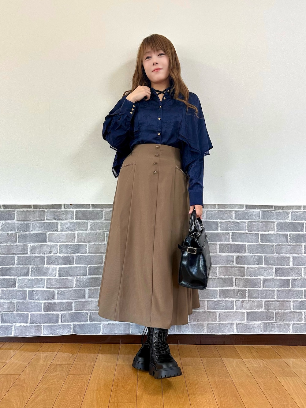 ブラック系のタンクトップ、ブルー系のシャツ/ブラウス、ブラウン系のスカートを着用したレディースの秋コーディネートの2枚目の写真